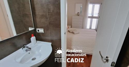La salle de bains est pourvue d'un lavabo et d'un lit dans la chambre. dans l'établissement Apartamento Calderón, Feel Cádiz, à Cadix