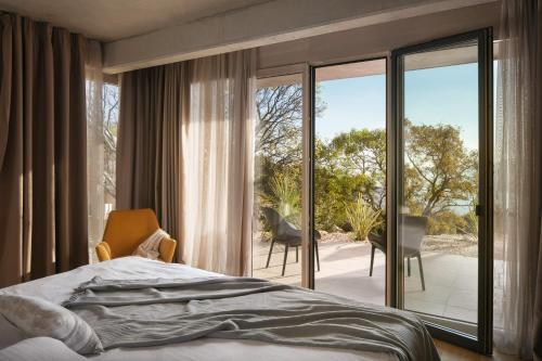 a bedroom with a bed and a large glass window at Green Tree Villas in Rabac