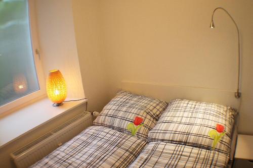 1 dormitorio con 1 cama con 2 almohadas y lámpara en Ferienwohnung im Alten Peter, en Goslar