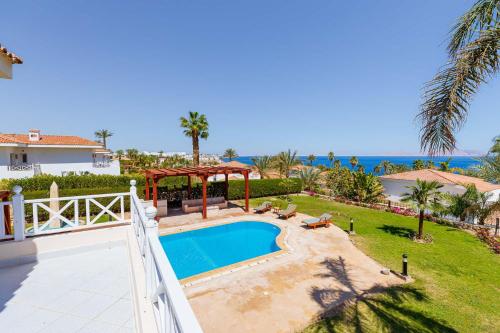 a villa with a swimming pool and a view of the ocean at Sharm and Charme at Sheraton Resort in Sharm El Sheikh