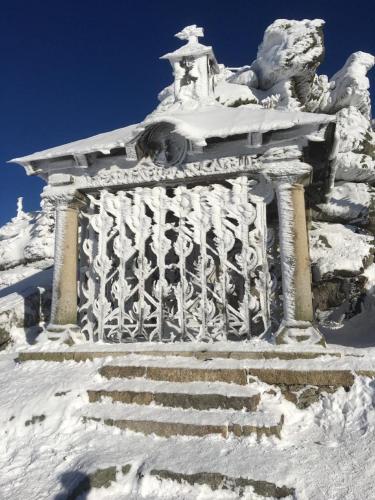 a building covered in snow with stairs in it at Ferienwohnung Hinterberg in Fürstenstein