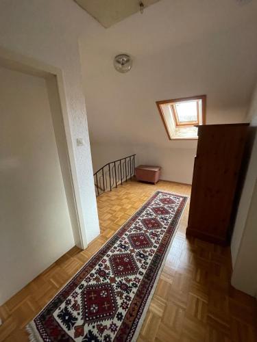 an empty room with a rug on a wooden floor at Ferienwohnung Hinterberg in Fürstenstein
