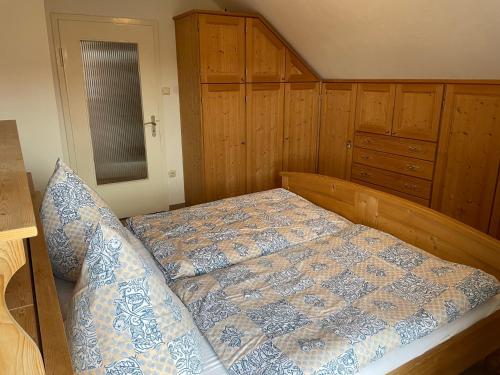 a bedroom with a bed and wooden cabinets at Ferienwohnung Hinterberg in Fürstenstein