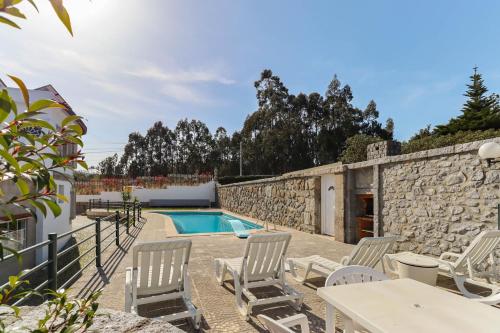 Villa con piscina y pared de piedra. en Casa do Calejo, en Viana do Castelo