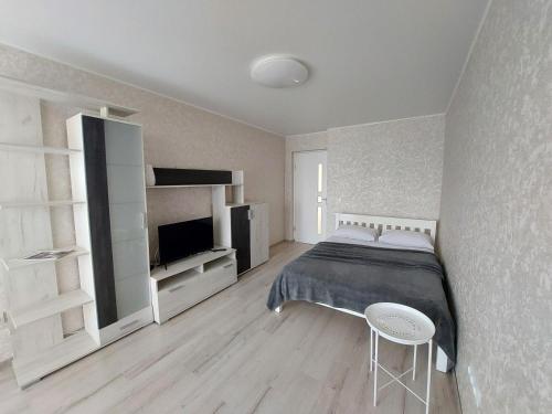 a white bedroom with a bed and a television at Апартаменти Молоді LutskDoba in Lutsk