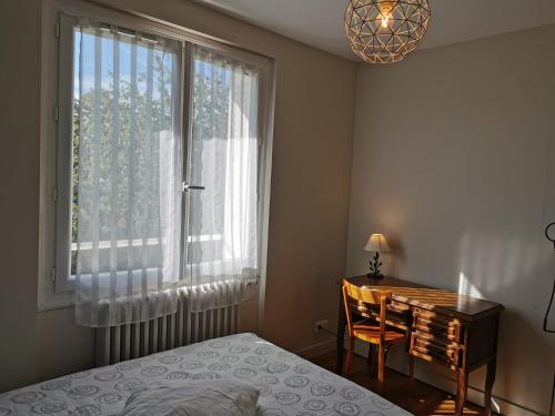 a bedroom with a bed and a desk and a window at Authentique Gîte 1950 Poitiers Futuroscope 1à9prsn, 3 Pkg, 3 étoiles à 6, Eco-Responsable in Poitiers