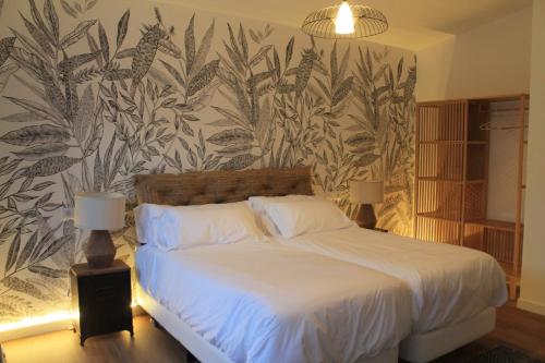 a bedroom with a bed with a tropical wallpaper at CASAS DA FORTALEZA Casa da Solaina in Outeiro de Rei