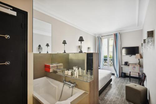 パリにあるLe Paris Singulierのバスルーム(バスタブ付)、ベッド1台、ベッドルーム1室が備わります。