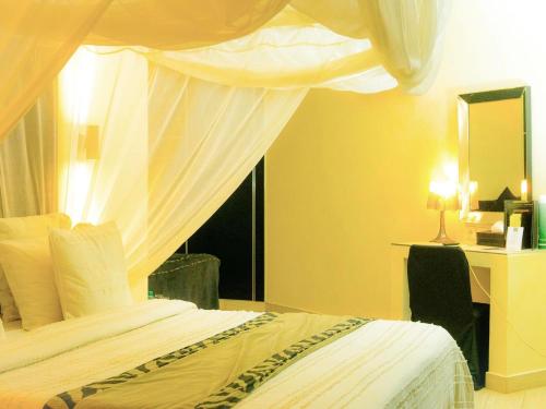 a bedroom with a bed with a canopy and a window at Villa Le Petit Paradis Saly Boutique Hotel in Ngaparou