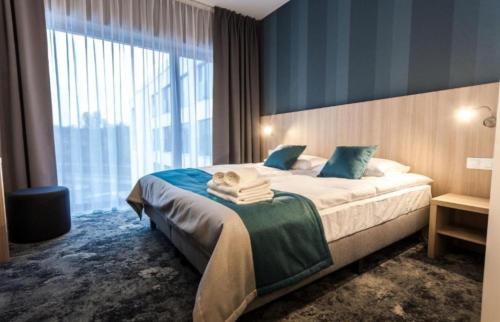 ein Hotelzimmer mit einem Bett und einem großen Fenster in der Unterkunft River apartments in Breslau