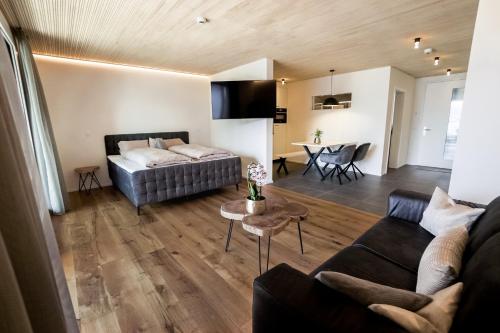 a living room with a couch and a table at Seehotel Baumgarten in Kehrsiten