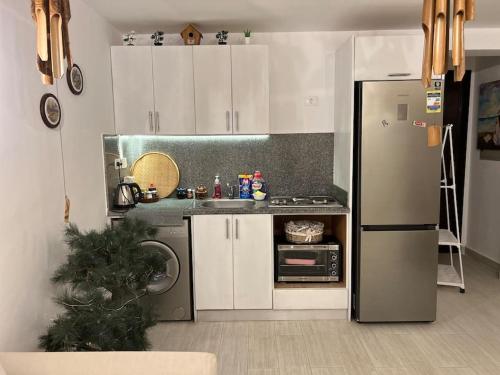 a kitchen with white cabinets and a stainless steel refrigerator at Classy studio at the beach with a pool in Hurghada