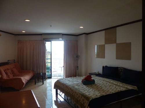 1 dormitorio con cama, sofá y ventana en View Talay 2 A en Jomtien Beach