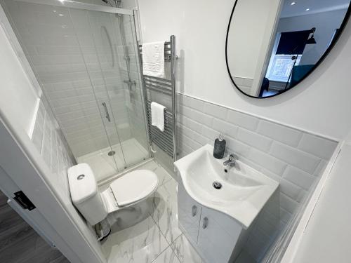 Baño blanco con lavabo y espejo en Regent Docks-Free Parking, en Liverpool