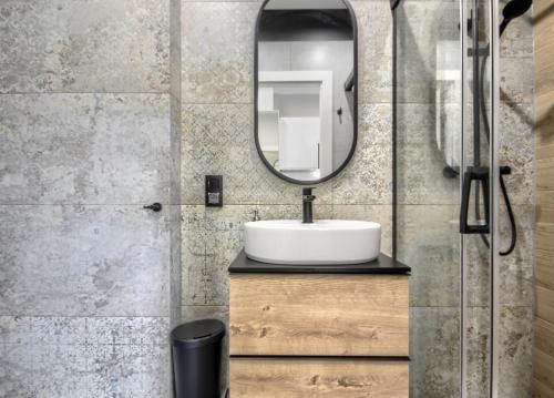 a bathroom with a sink and a mirror at Studio Bueno 5.4 - ACCO RENT in Gdańsk