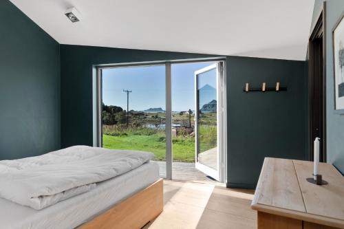 1 dormitorio con paredes verdes, 1 cama y mesa de madera en Skagenhaugen en Skagen
