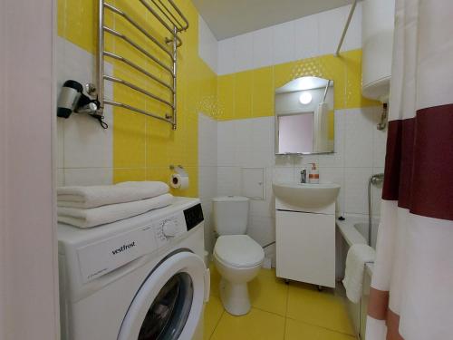 Апартаменти Молоді LutskDoba في لوتسك: حمام فيه غساله وغساله ملابس