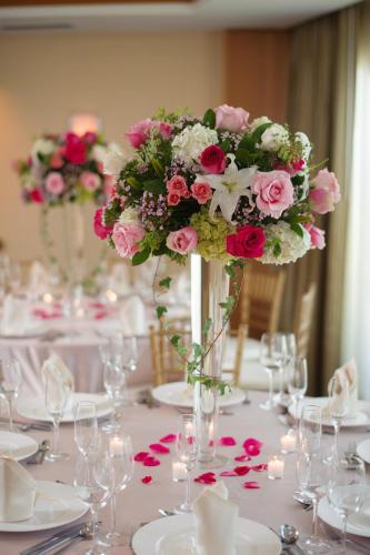 einen Tisch mit einer Vase voller rosa und weißer Blumen in der Unterkunft Edgewater Beach Hotel in Naples
