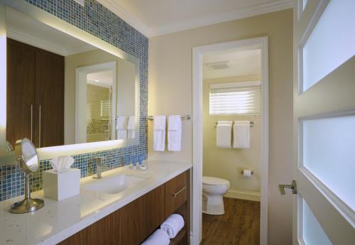 a bathroom with a sink and a toilet and a mirror at Edgewater Beach Hotel in Naples