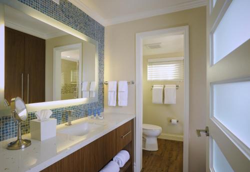 a bathroom with a sink and a toilet and a mirror at Edgewater Beach Hotel in Naples