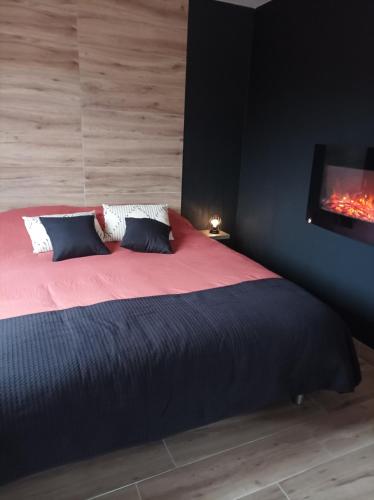 a bedroom with a bed with a tv on the wall at Loft sauna jacuzzi ospariegeois in Lavelanet