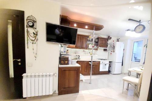 eine Küche mit einem Kühlschrank und einem TV an der Wand in der Unterkunft Comfort StudioCity with balcony in Kamjanez-Podilskyj