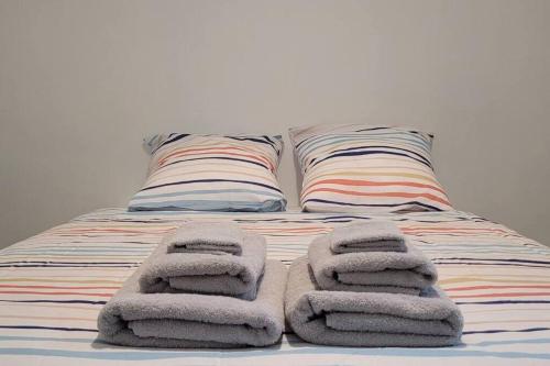 - un lit avec des serviettes assises au-dessus dans l'établissement La Maison Spacieuse, 