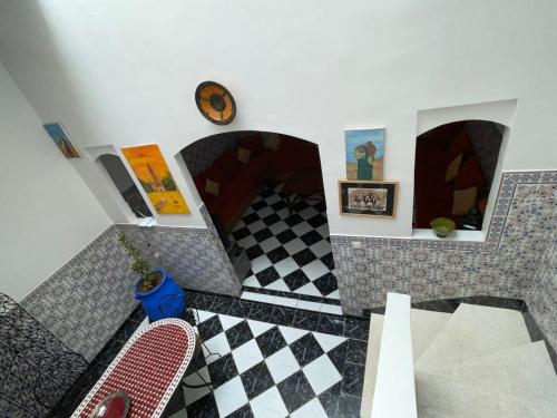 a room with a checkered floor and a clock at Riad NEJJARINE in Marrakesh