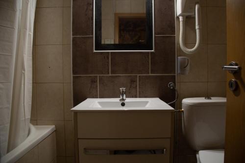 a bathroom with a sink and a toilet and a mirror at Hotel Moment in Velika Plana