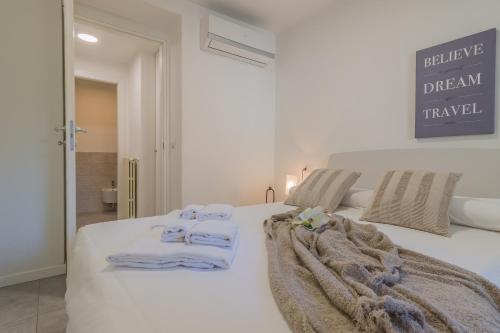 ein Schlafzimmer mit einem weißen Bett und Handtüchern darauf in der Unterkunft Il giardino di Alice in Varenna