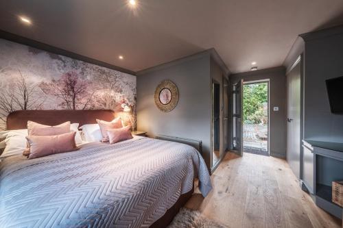 ein Schlafzimmer mit einem großen Bett mit rosa Kissen in der Unterkunft The Cricketers Clavering in Clavering