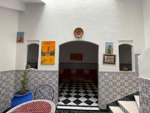 a room with a table and a clock on a wall at Riad NEJJARINE in Marrakesh