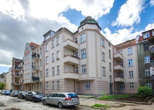 a large building with cars parked in front of it at Studio Mini Apart 6.2 - ACCO RENT in Gdańsk