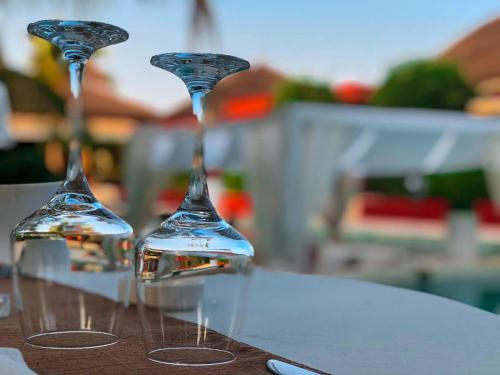 two wine glasses sitting on top of a table at Villa Le Petit Paradis Saly Boutique Hotel in Ngaparou