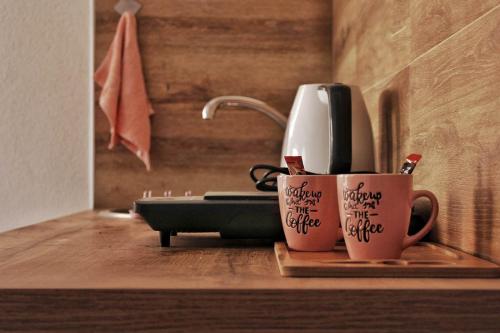 two coffee mugs with writing on them on a counter at My place studio in Ohrid