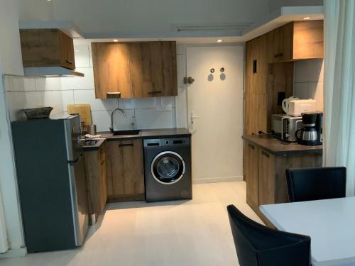 une cuisine avec une machine à laver et un lave-vaisselle dans l'établissement Studio centre ville, à Aix-les-Bains
