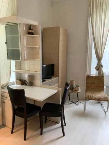 une pièce avec une table, des chaises et une télévision dans l'établissement Studio centre ville, à Aix-les-Bains