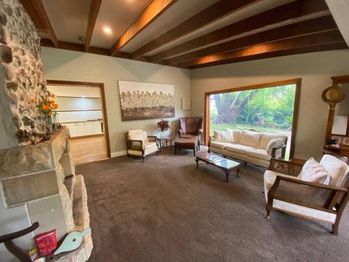 a living room with couches and a stone fireplace at The Barn, Bowral in Bowral