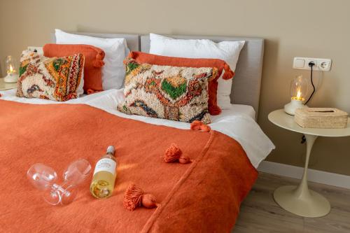 a bed with a orange blanket and a bottle on it at Hotel Restaurant Toxopeus in Anjum