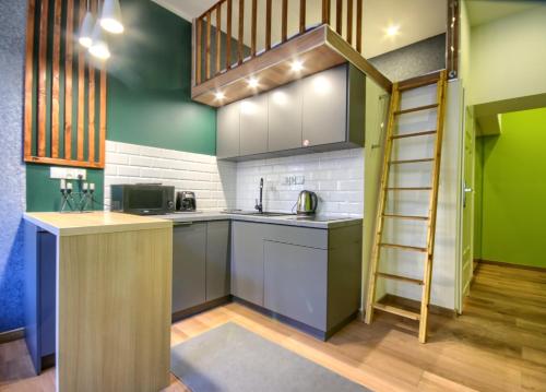een keuken met groene muren en een ladder bij Studio Mini Apart 6.3 - ACCO RENT in Gdańsk