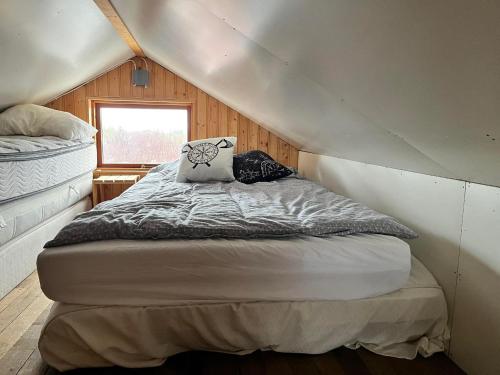 a bed with two pillows on it in a room at Vörðufell Country Cabin in Selfoss