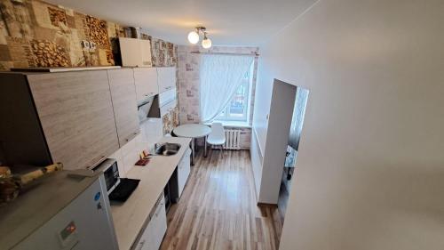 eine Küche mit weißen Schränken und einem großen Fenster in der Unterkunft Sakņu 16/18 in Daugavpils
