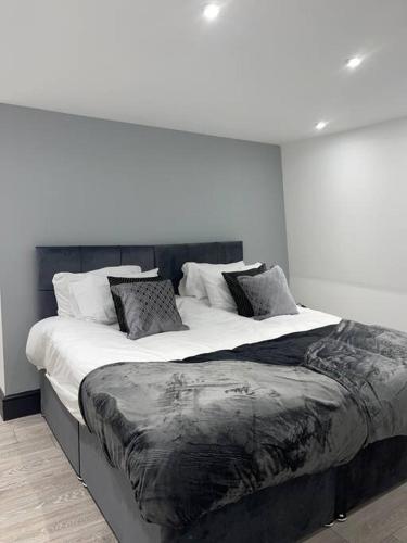 ハンティンドンにあるAbacus House - TWO Bedroom Apartmentの白い壁の客室の大型ベッド1台分です。