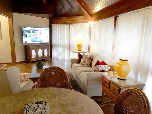 a living room with a couch and a table at Center Suiço Flats in Campos do Jordão