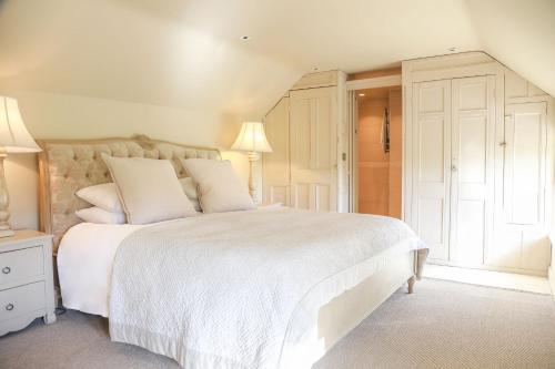 a bedroom with a large white bed with white pillows at Wiveton Bell in Blakeney