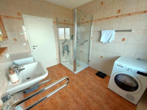 a bathroom with a washing machine and a sink at Apartments im Taunus in Neu-Anspach