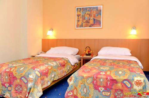 dos camas sentadas una al lado de la otra en una habitación en Bellis Hotel, en Sankt Urban