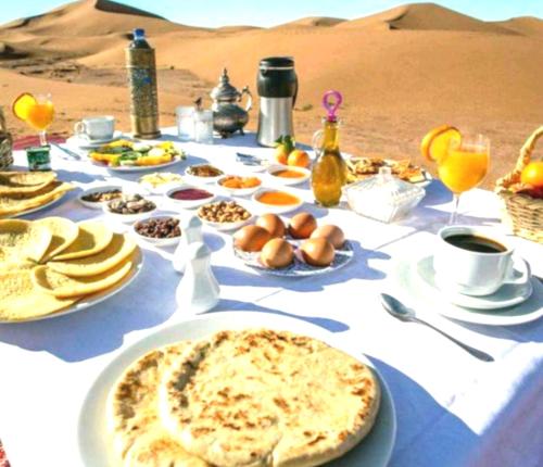 een tafel met eten in de woestijn bij Original Luxury Camp in Merzouga