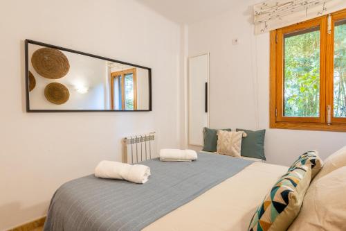 una camera da letto con un letto e uno specchio sul muro di Holytom Puerto Pollensa a Port de Pollença