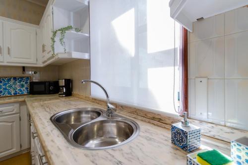 encimera de cocina con fregadero y ventana en Apartment close to the Ria de Aveiro, São Jacinto en Aveiro